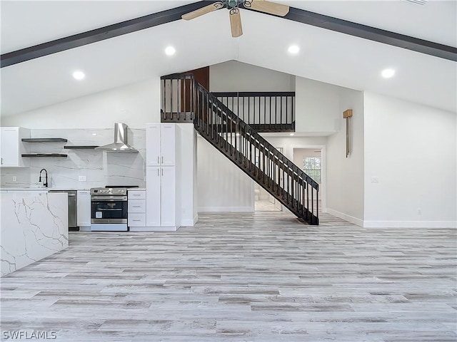 kitchen with sink, wall chimney range hood, electric range, white cabinets, and light wood-type flooring