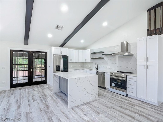 kitchen featuring sink, vaulted ceiling with beams, stainless steel appliances, white cabinets, and a kitchen island