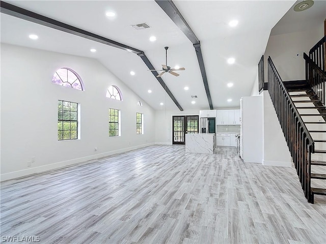 unfurnished living room featuring ceiling fan, high vaulted ceiling, a healthy amount of sunlight, and light wood-type flooring