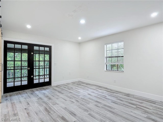 spare room featuring light hardwood / wood-style flooring and french doors