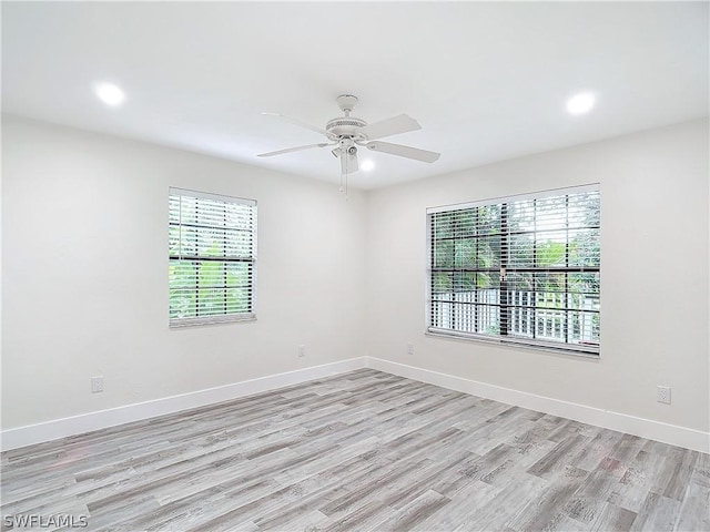 unfurnished room with a wealth of natural light, ceiling fan, and light hardwood / wood-style flooring