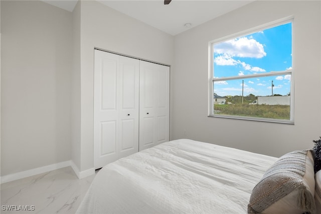 bedroom featuring multiple windows, a closet, and ceiling fan