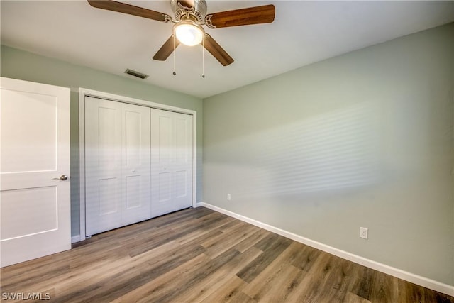 4508 Santa Barbara Blvd Unit 102, Cape Coral, FL 33914 - unfurnished bedroom featuring baseboards, wood finished floors, a closet, and a ceiling fan