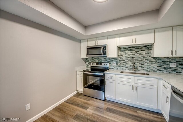 4508 Santa Barbara Blvd Unit 102, Cape Coral, FL 33914 - kitchen featuring stainless steel appliances, a sink, light countertops, and white cabinets