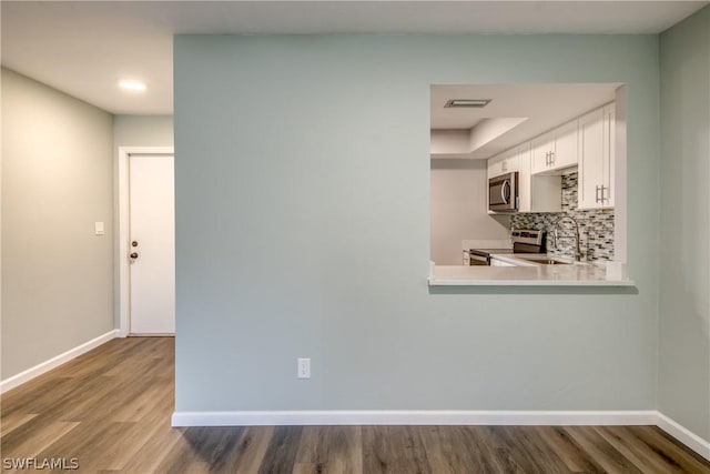 4508 Santa Barbara Blvd Unit 102, Cape Coral, FL 33914 - kitchen with stainless steel appliances, a sink, light countertops, wood finished floors, and baseboards