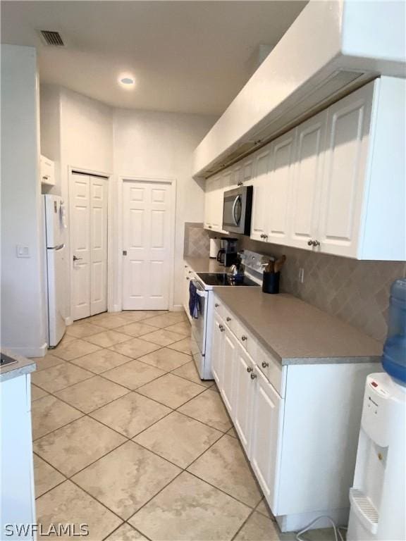 kitchen with light countertops, visible vents, decorative backsplash, white cabinetry, and white appliances