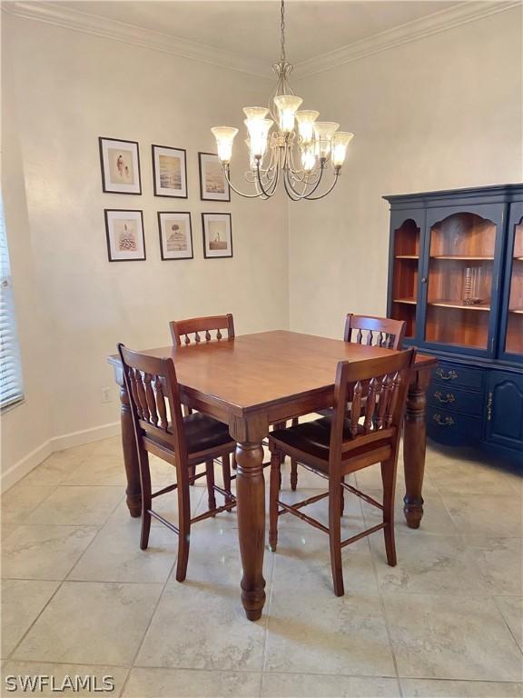 dining room featuring crown molding, baseboards, and an inviting chandelier