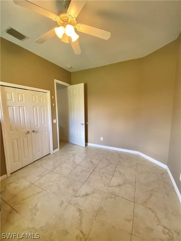 unfurnished bedroom with vaulted ceiling, a closet, and ceiling fan