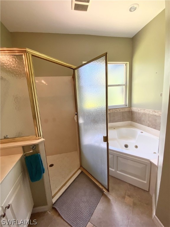 bathroom featuring tile patterned flooring, vanity, and plus walk in shower