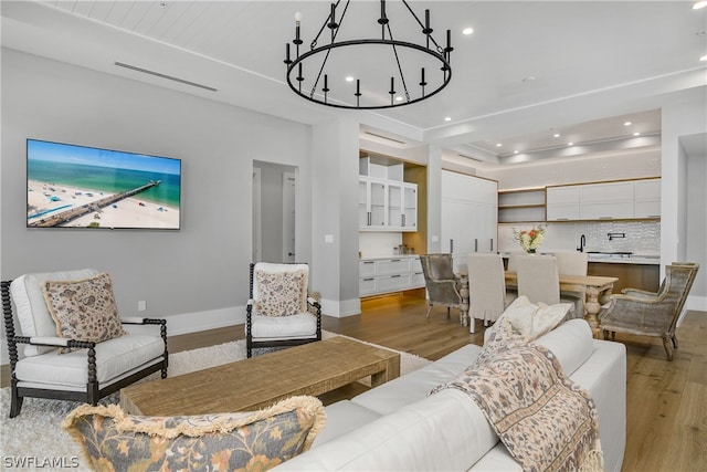 living room featuring a chandelier and light hardwood / wood-style floors