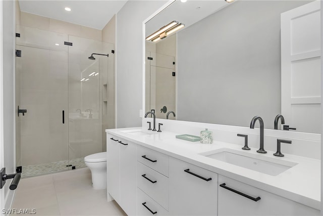 bathroom with tile patterned flooring, vanity, a shower with shower door, and toilet