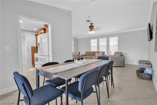 dining room featuring ornamental molding, light tile patterned flooring, visible vents, and a ceiling fan