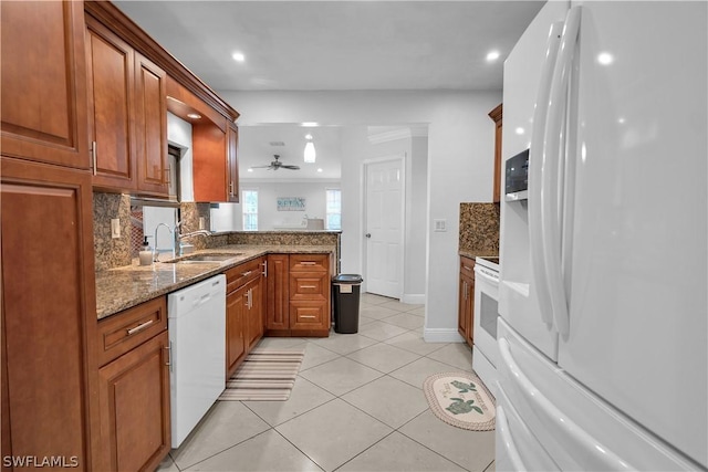 kitchen featuring stone counters, light tile patterned floors, decorative backsplash, a sink, and white appliances