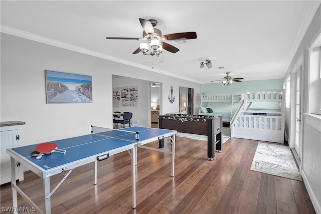 recreation room with crown molding, dark hardwood / wood-style flooring, and ceiling fan