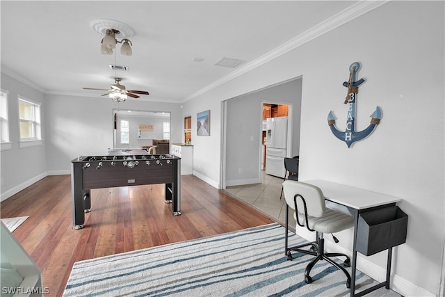 game room with crown molding, ceiling fan, and light tile patterned floors