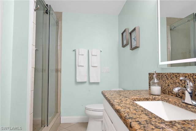 bathroom featuring vanity, an enclosed shower, tile patterned flooring, and toilet