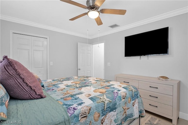 bedroom featuring a ceiling fan, a closet, visible vents, and crown molding