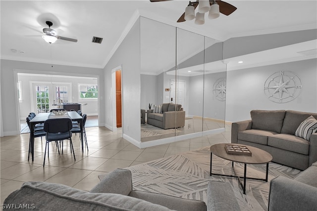 living room with vaulted ceiling, french doors, crown molding, light tile patterned flooring, and ceiling fan