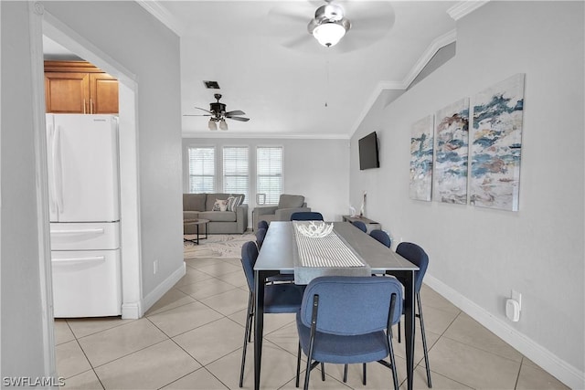 dining area with lofted ceiling, light tile patterned floors, ceiling fan, and ornamental molding