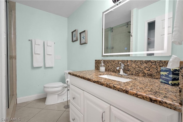 full bath with a stall shower, baseboards, toilet, tile patterned flooring, and vanity