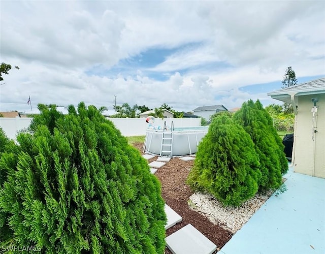 view of yard featuring fence and a fenced in pool