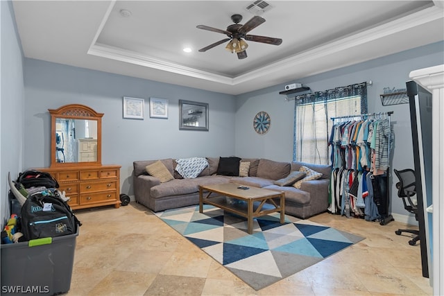 tiled living room featuring crown molding, ceiling fan, and a raised ceiling