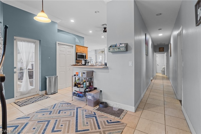 corridor featuring crown molding and light tile patterned floors