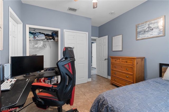 bedroom featuring a closet, light tile patterned floors, and ceiling fan