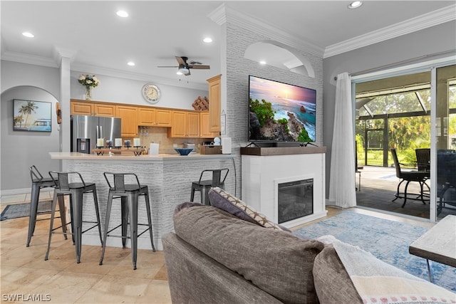 living room featuring light tile patterned flooring, ceiling fan, and crown molding