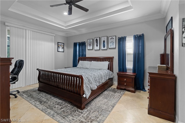 tiled bedroom featuring ornamental molding, ceiling fan, and a tray ceiling