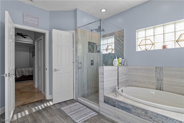 bathroom featuring shower with separate bathtub, ceiling fan, and hardwood / wood-style floors