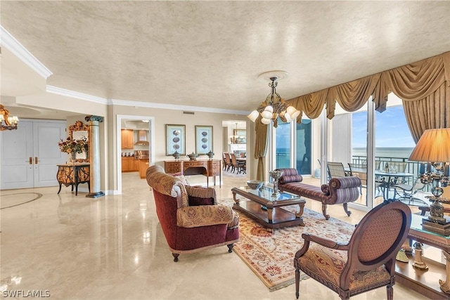 living room with a textured ceiling, ornamental molding, a chandelier, and a water view