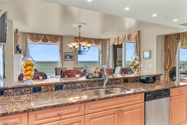 kitchen featuring sink, dishwasher, a water view, a notable chandelier, and light brown cabinets