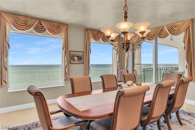 dining space with a notable chandelier and a water view