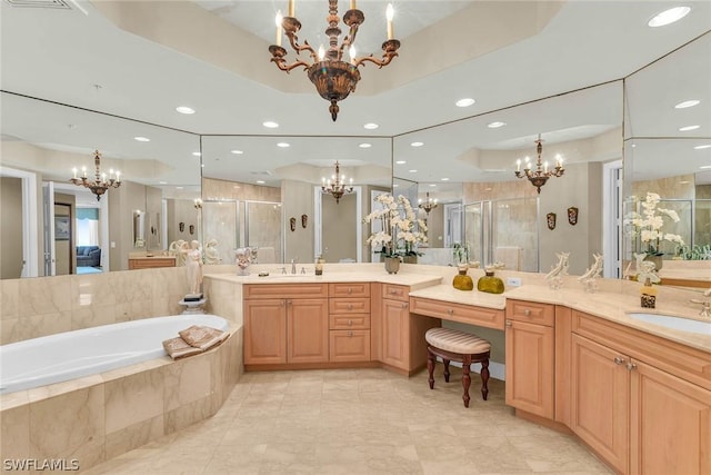 bathroom featuring vanity, a notable chandelier, independent shower and bath, and a raised ceiling