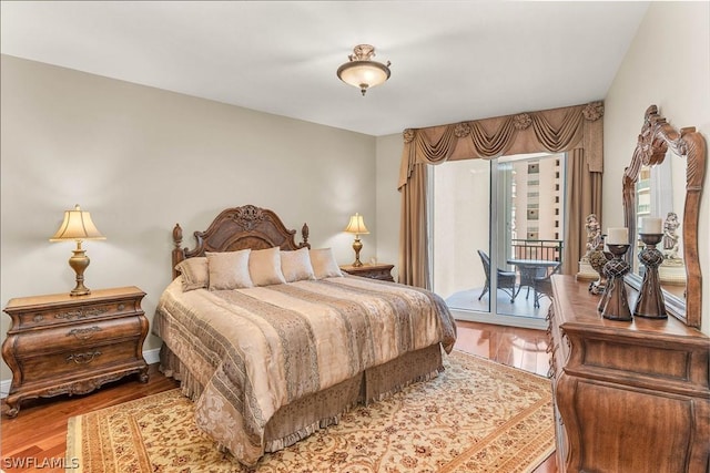 bedroom with wood-type flooring and access to outside