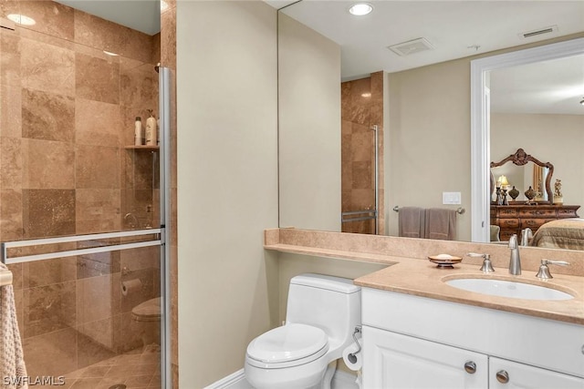 bathroom featuring vanity, a shower with door, and toilet