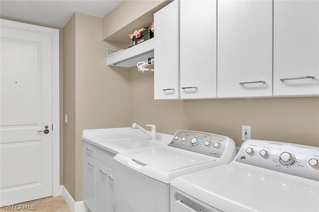 laundry area featuring cabinets, separate washer and dryer, sink, and light tile patterned floors