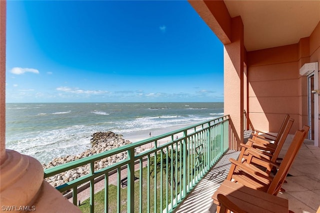 balcony with a water view and a beach view