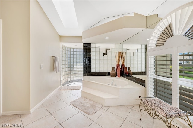 bathroom with lofted ceiling, baseboards, a bath, and tile patterned floors