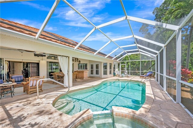 view of swimming pool with a patio, ceiling fan, an in ground hot tub, and glass enclosure