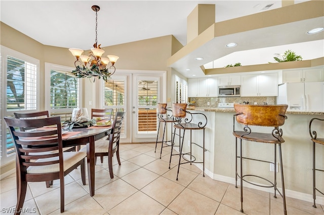 dining room featuring light tile patterned floors, visible vents, lofted ceiling, a notable chandelier, and recessed lighting