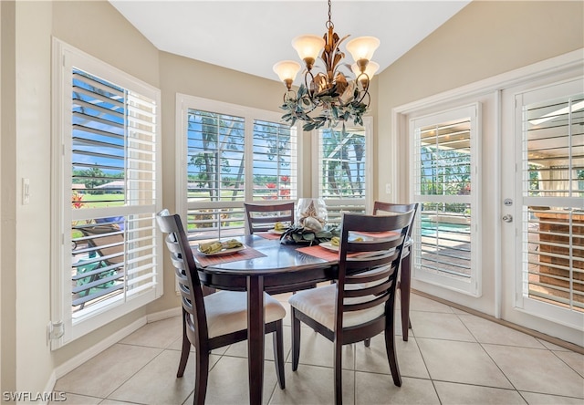 dining room with lofted ceiling, baseboards, a notable chandelier, and light tile patterned flooring