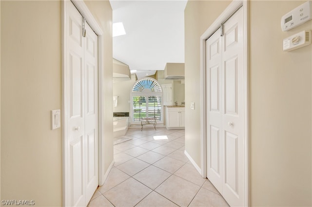 hallway featuring light tile patterned floors and baseboards