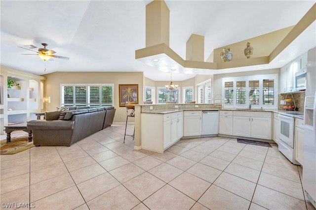 kitchen featuring light tile patterned floors, open floor plan, white cabinetry, white appliances, and a peninsula