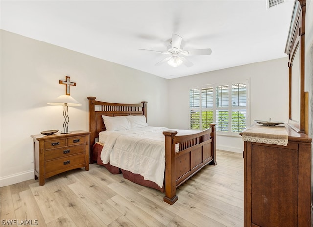 bedroom with light wood-style flooring, visible vents, baseboards, and a ceiling fan