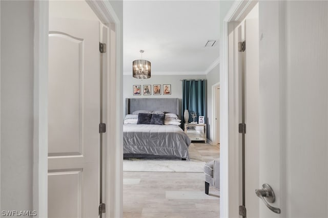 bedroom featuring ornamental molding, a notable chandelier, and wood-type flooring