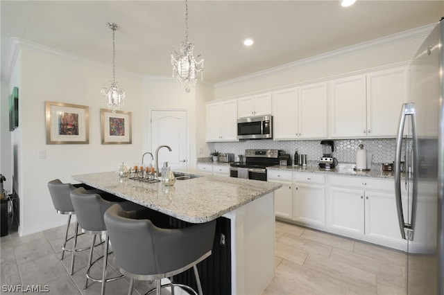 kitchen with stainless steel appliances, sink, white cabinetry, hanging light fixtures, and a center island with sink