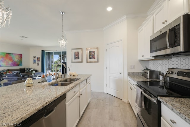 kitchen featuring stainless steel appliances, sink, white cabinets, light stone countertops, and a chandelier