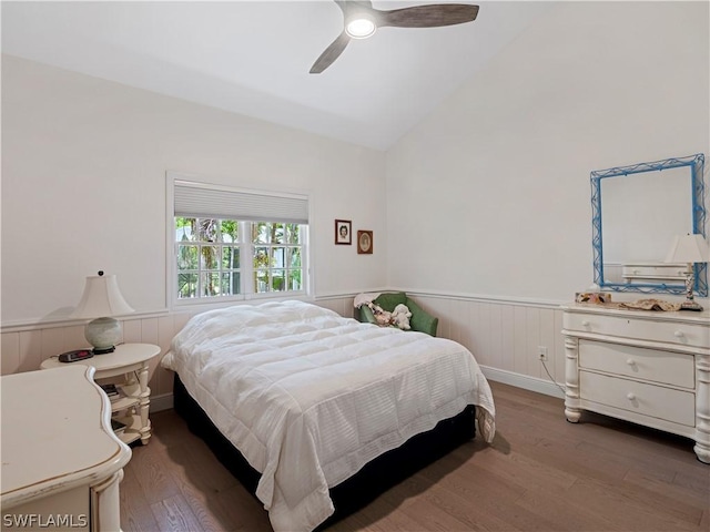 bedroom with ceiling fan, vaulted ceiling, and dark wood-type flooring